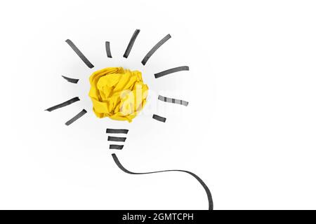 Idea concept with light bulb made out of yellow crumbled paper ball and drawn black lines on white background Stock Photo