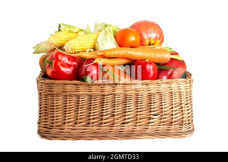 Basket with summer and autumn vegetables on a white background. Bell pepper, carrots and corn cobs with tomatoes, isolate, Healthly food Stock Photo
