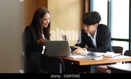 Two of colleagues happy to work together, businesswoman and businessman discussing work in office. workplace relationship Stock Photo