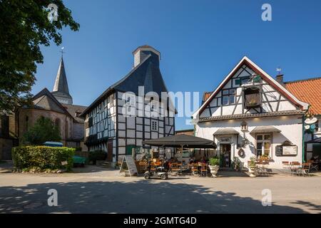 Germany, Wuelfrath, Wuelfrath-Duessel, Bergisches Land, Niederbergisches Land, Niederberg, Rhineland, North Rhine-Westphalia, NRW, Dorfstrasse in the Duessel village, f.l.t.r. catholic church Saint Maximin, half-timbered house Eyser, former sextons house and school, house 'Am Iser' with Kutscherstuben restaurant and cafe Stock Photo