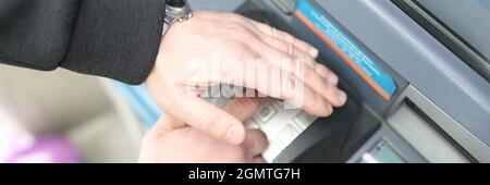 Man enters code on ATM keyboard and closes it with his hand Stock Photo