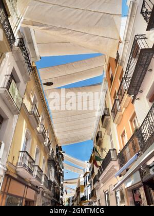Seville, Andalucia, Spain - 31 May 2016; no people in view.Cloth awnings protect shoppers and pedestrians from the fierce summer sun in Calla Sierpes, Stock Photo