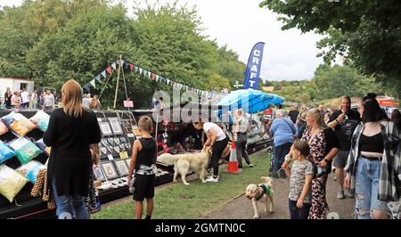 At The Black Country Boating Festival 2021 the crowds are having a look at the crafts, from cushions, to art work being sold from a canal Narrowboat, Stock Photo