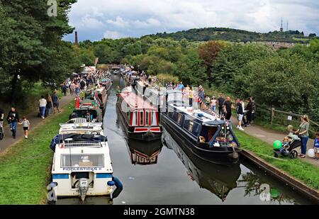 A canal hire boat passes through The Black Country Boating Festival 2021 being held on the Dudley no2 canal at Bumble Hole in Netherton. Stock Photo