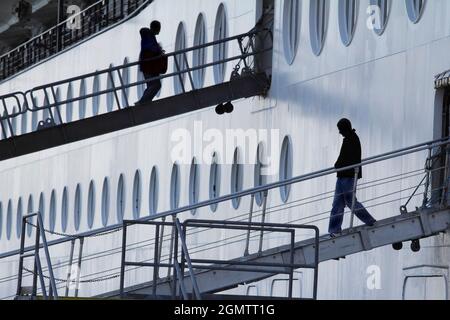 Ketchikan, Alaska USA - 26 May 2010; silhouetted people in view. Here we see passengers embarking and disembarking whilst a cruise liner is moored in Stock Photo