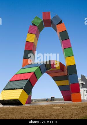 Le Havre, Normandy, France - 30 May 2017; a single person is sitting on a bench. A monumental sculpture - made out of freight containers - is a fittin Stock Photo