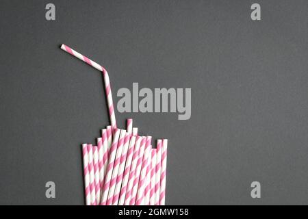 Glass with straw made up of paper straws on black background. Party or no plastic concept. Stock Photo