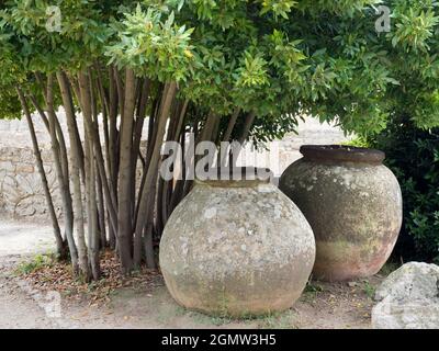 Catania, Sicily, Italy - 22 September 2019    Massive stone pots and an old wall in a garden outside an ancient villa near Catania on Sicily's east co Stock Photo