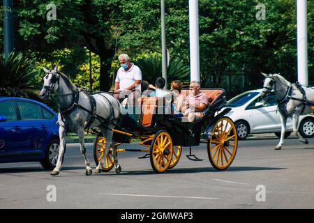 Seville Spain September 15, 2021 Horse drawn carriage ride through the streets of Seville during the coronavirus outbreak hitting Spain, wearing a mas Stock Photo
