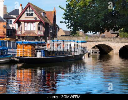Oxford, England - 29 August 2019; A tranquil scene by Thames at Oxford, with a pleasure boat moored Bridge on a bright morning in late summer. The boa Stock Photo