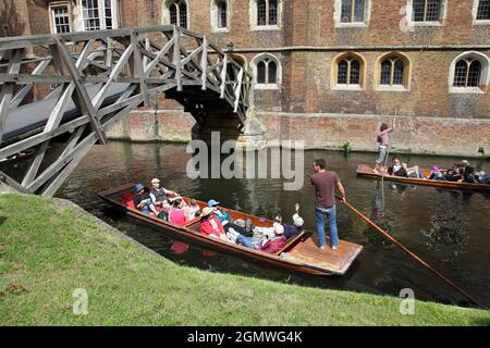 Punting on the River Cam in summer, approaching Mathematical Bridge of Queens' College, Cambridge. The distinctive  bridge was designed by William Eth