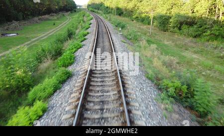 The speed of flight over the rails of the tracks on which the train goes outside the city Stock Photo