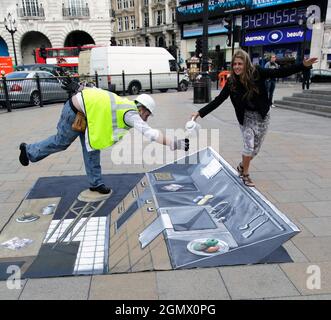 London, England  -  9 September 2009; a man, woman and passers by in shot. I have no idea what is going on here in Piccadilly Circus, in the heart of Stock Photo