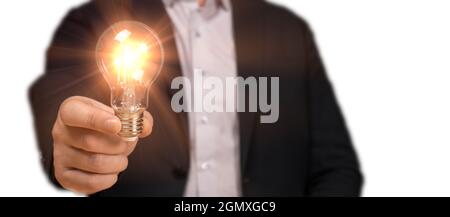 idea concept with innovation and inspiration. businessman in suit holding idea bulb in hand isolated on white. man holding light bulbs, innovative tec Stock Photo