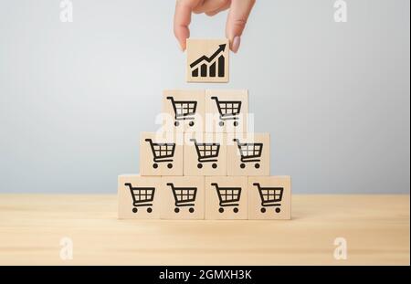 sale volume increase make business grow, Flips cube with icon graph and shopping cart symbol. Retail and Sales growth concept. businesswoman flips cub Stock Photo