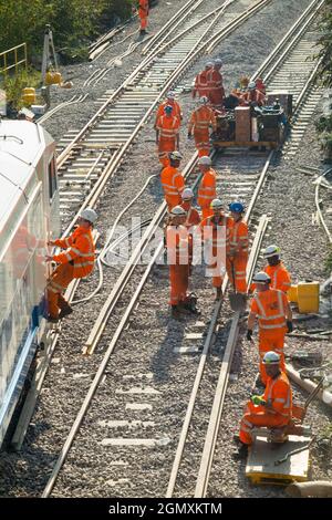 Network Rail / Networkrail workers performing core work – track replacement using heavy machinery and engineering trains. Upgrading out of date wooden sleepers with modern concrete sleepers and new rails at Twickenham in West London. UK (127) Stock Photo