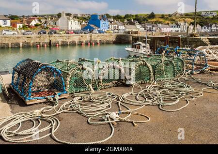 Lobster creels on quay of harbour in small picturesque west coast fishing village.  Portpatrick, Dumfries and Galloway, Scotland, UK, Britain Stock Photo