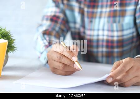 man hand in fountain pen writing or signature on paper . Stock Photo