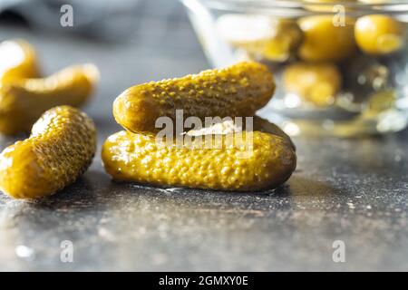 Small pickles. Marinated pickled cucumbers on kitchen table. Stock Photo