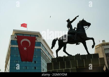Izmir, Turkey - September 9, 2021: Ataturk statue at the Republic square in Izmir with a Turkish flag in the same frame. Stock Photo