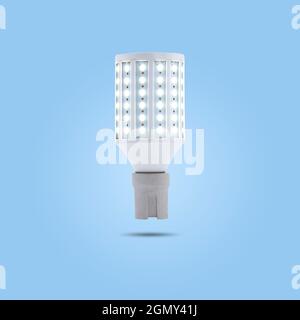 LED energy saving lamp 230v in a ceramic socket isolated on blue pastel color background. Stock Photo