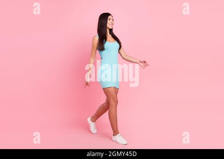 Full size profile photo of optimistic lady wear blue dress sneakers isolated on pink color background Stock Photo