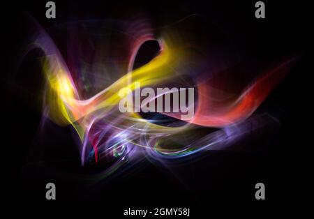 Light-painting photography. Colored lights forming abstract shapes on a black background. Night photography. Stock Photo