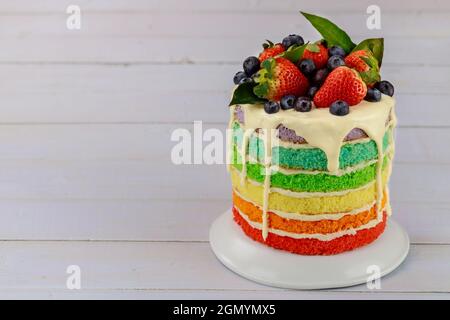 Festive multi layered cake with fresh strawberry. Birthday rainbow cake. Stock Photo