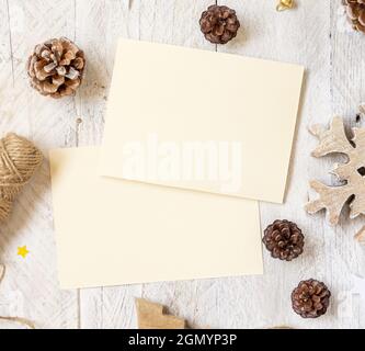 Winter Christmas Composition with a cards flat lay. Christmas and New Year greeting card template with pine cones, wooden decorations and rope on marb Stock Photo