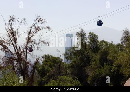Cable cars in San Cristobal mountain park with Santiago building landmark on background. Chile capital tourism concept Stock Photo