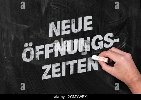 text NEUE OFFNUNGSZEITEN, German for new opening hours, written on chalkboard Stock Photo