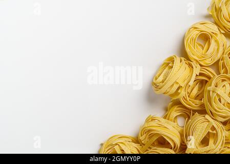 Fettuccine italian pasta isolated on white background. Raw tagliatelle nests isolated on white background. Traditional Italian pasta Stock Photo