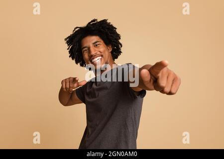 Joyful Young African American Guy Poiting At Camera With Two Hands Stock Photo