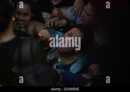 Kathmandu, Nepal. 21st Sep, 2021. Nepalese women struggle to drink homemade alcohol from the mouth of Deity Swet Bhairav as blessings during Indra Jatra festival in Kathmandu, Nepal on Tuesday, September 21, 2021. (Credit Image: © Skanda Gautam/ZUMA Press Wire) Stock Photo