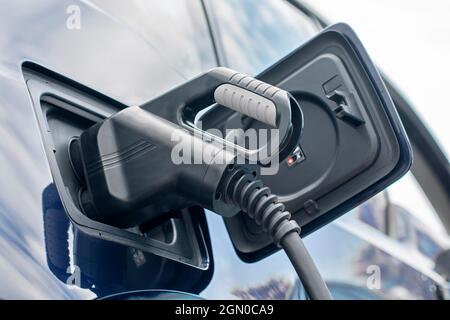 Power cable pump plug in charging power to electric car Stock Photo