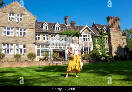 Woman outside Ockenden Manor Hotel in Cuckfield near Haywards Heath , Sussex , England , UK Stock Photo