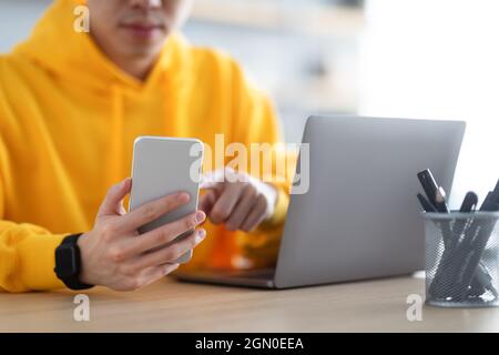 Closeup of man sitting at desk reading text message Stock Photo