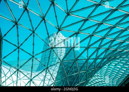 Low angle of curved glass roof with geometric shapes of modern building designed in futuristic style Stock Photo