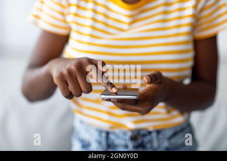 Unrecognizable black woman using brand new mobile phone Stock Photo
