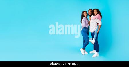 African American dad giving piggyback ride to his daughter Stock Photo