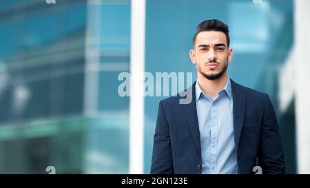 Handsome middle-eastern guy businessman posing next to office center Stock Photo