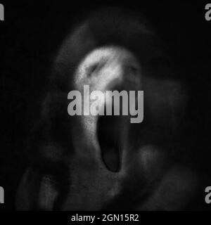 Scream of horror. Screaming ghost face. Scary Halloween mask. Shot with long exposure. Stock Photo
