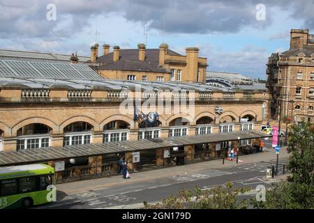 Exterior of the main entrance to York railway station with people, bus stop, station clock and British Rail double arrow logo, 11th September 2021. Stock Photo