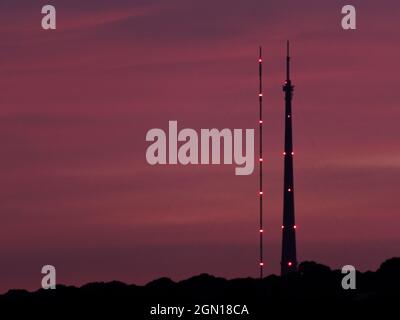Emley Moor Transmitting Station, in Wakefield, West Yorkshire silhouetted against a purple sunset. Left is the temporary tower, right is the Arqiva To Stock Photo