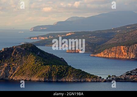 View over the rugged west coast to the north, in the foreground the town of Assos with its castle, Kefalonia Island, Ionian Islands, Greece Stock Photo