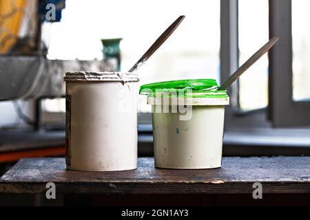 cans with plastisol (paint) on a wooden shelve on the print screening apparatus. serigraphy production. printing images by silk screen method Stock Photo