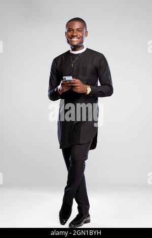 handsome young african man smiling while using his phone Stock Photo