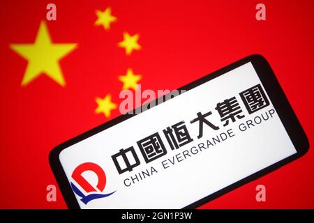 In this photo illustration a China Evergrande Group logo is seen on a smartphone screen with a Chinese flag in the background. Stock Photo