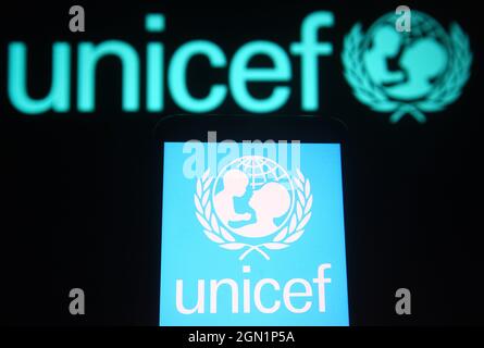 In this photo illustration the UNICEF (United Nations Children's Fund) logo is seen on a smartphone and a pc screen. Stock Photo