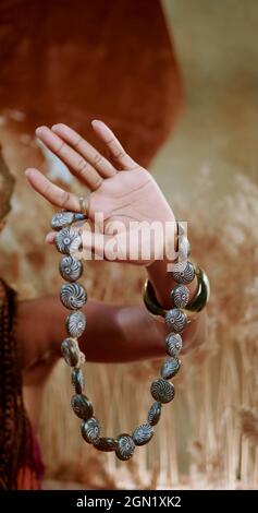 A vertical photo of an African hand which is holding a traditional necklace Stock Photo